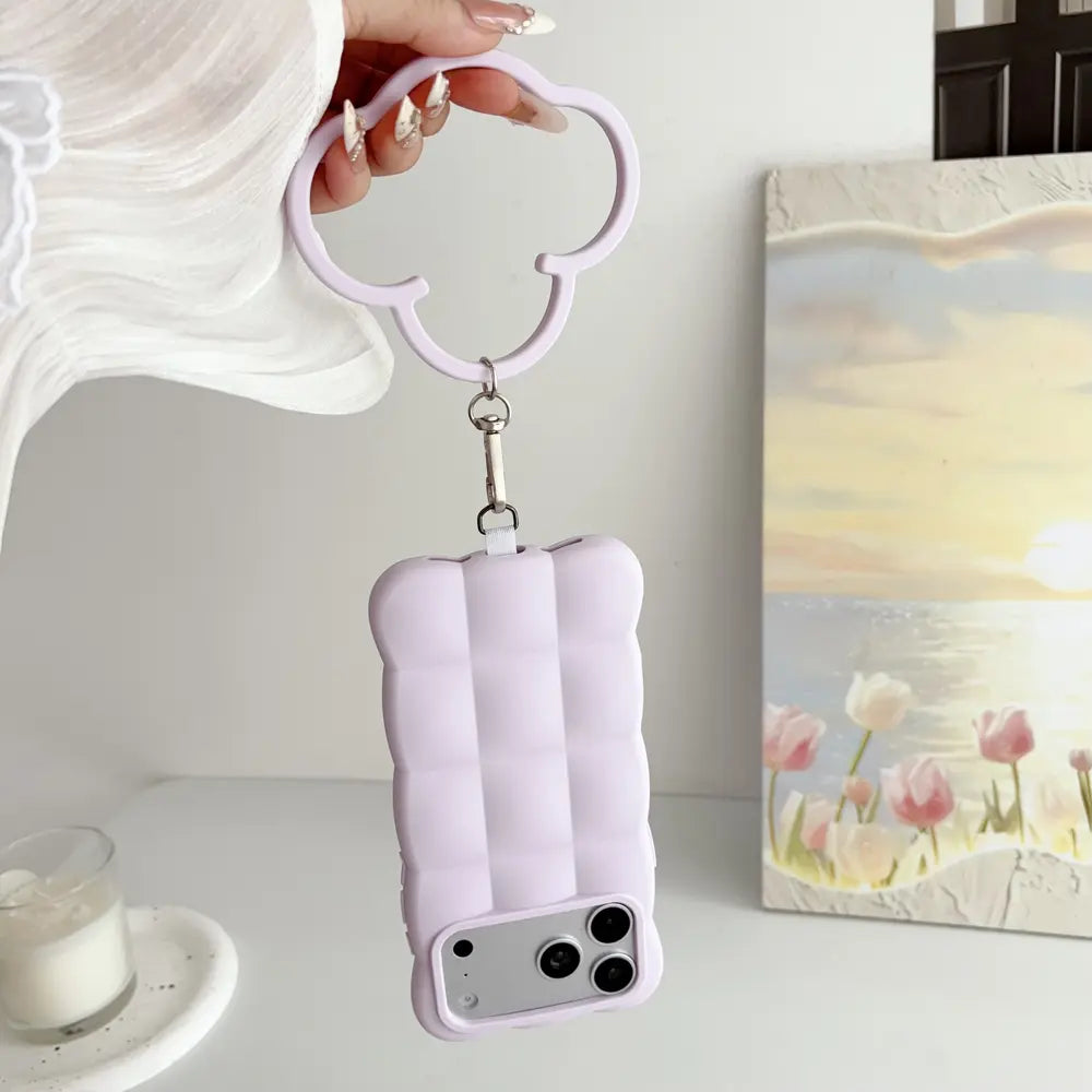 Lilac puffer silicone phone case for iPhone 18 Pro Max, handheld view with cloud‑shaped wrist ring