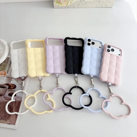 Pastel puffer silicone phone case for iPhone 18 Pro Max with cloud wrist ring, 6‑color flat lay display